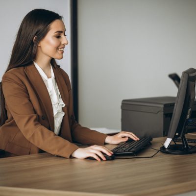 Young business woman working on laptop in office